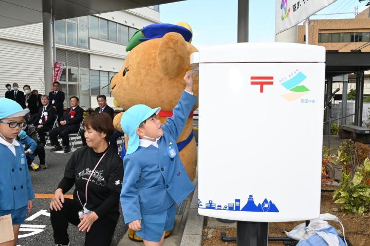 紙のまちをイメージした真っ白な郵便ポストに手紙を投函（とうかん）する園児（写真を一部加工しています）