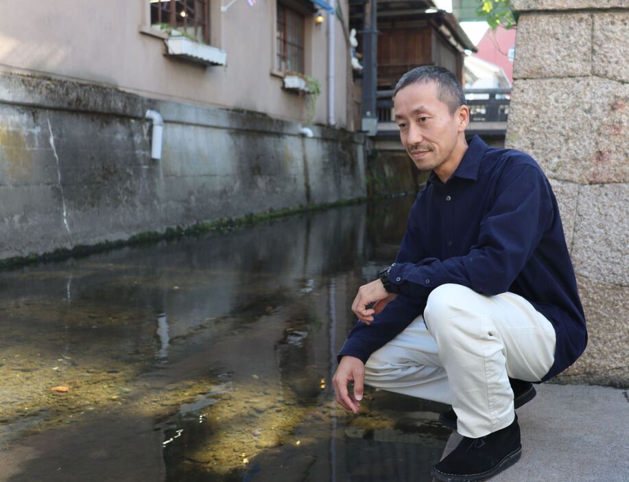 「アユもいるんですよ」と笑って米川を眺める竹村さん（長浜市元浜町）