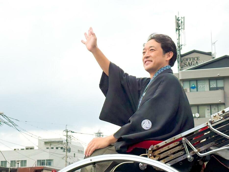 沿道に詰めかけたファンに向かって笑顔で手を振る、江藤新平役の迫田孝也さん