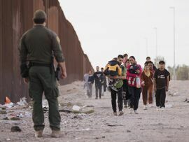 A US Customs and Border Protection officer near migrants at the US-Mexico border in Lukeville, Arizona.