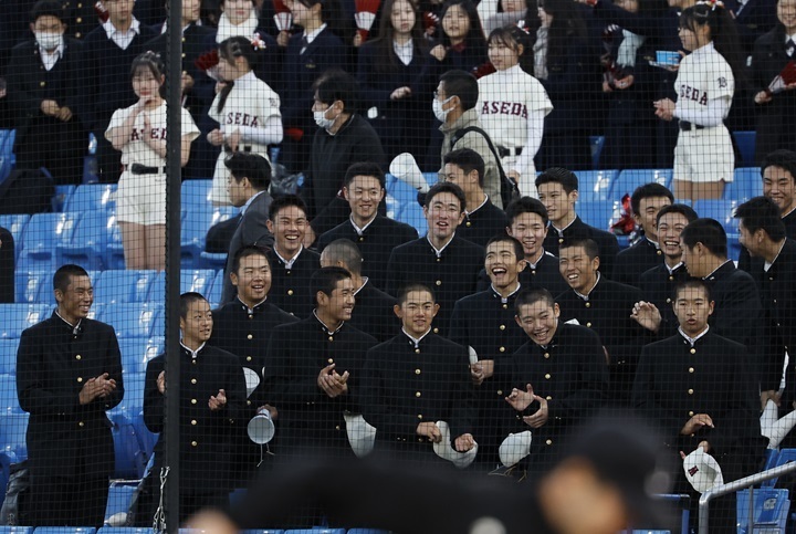 一塁スタンドでは3年生部員も声援を送った。今夏の甲子園3回戦へとけん引した主将・宇野真仁朗[ソフトバンク4位指名、3列目左端]の姿もあった[写真=田中慎一郎]