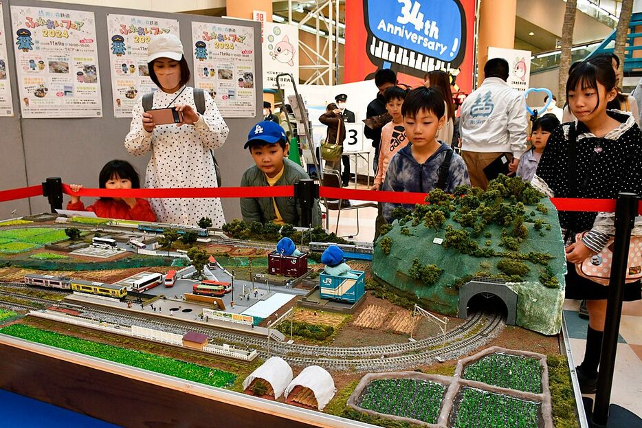 Nゲージの鉄道模型にじっくりと見入る子どもたち＝9日、八戸市の八戸ショッピングセンターラピア