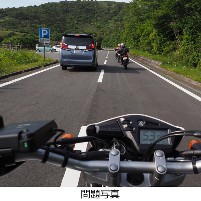 山道をツーリング中で、友人のバイクに続いてミニバンを追い越そうとしています。