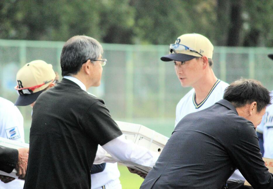 　セレモニーで贈呈品を受け取る岸田監督（右）