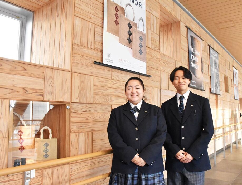 青森駅自由通路では、生徒が手がけた製品を展示している。井上さん（左）と立花さんは「多くの人に知ってもらいたい」＝29日