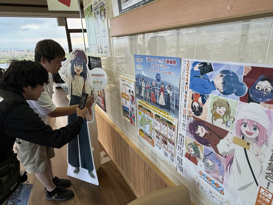 アニメ「ゆるキャン△」ゆかりの地でスタンプを獲得するファン。静岡来訪のきっかけになっている＝6日午後、富士市の富士川楽座