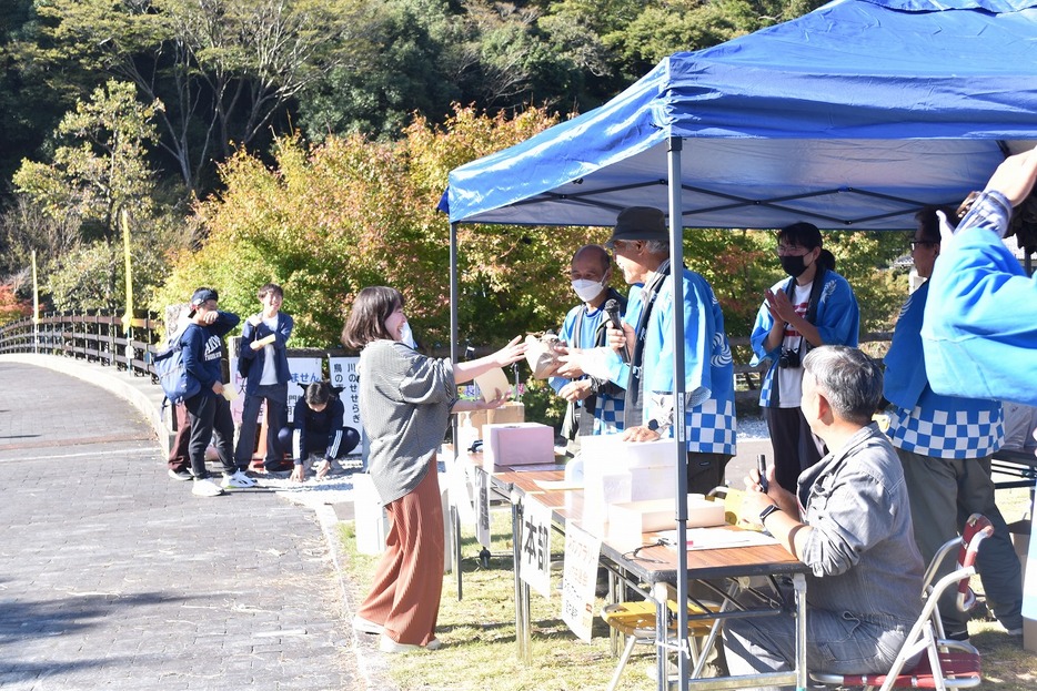 抽選で米が当たって喜ぶ参加者（長門峡入り口周辺で）