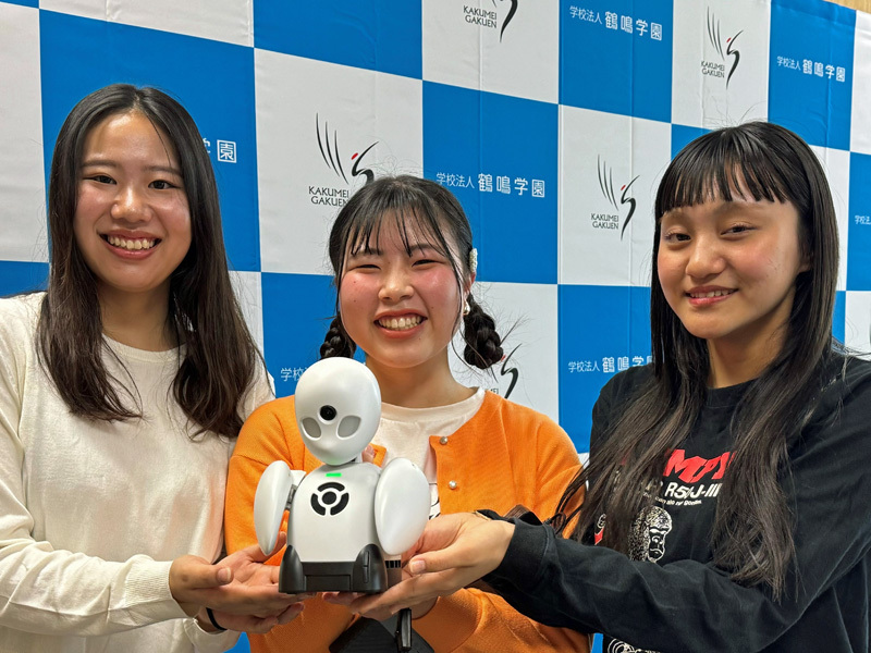 学生サポーターに抱えられた分身ロボット「ＯｒｉＨｉｍｅ」＝長崎市弥生町、長崎女子短大