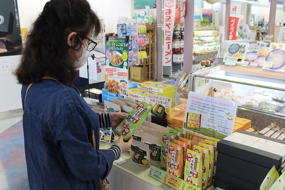 「うかるっ茶」を手に取る空港利用者（山口宇部空港で）