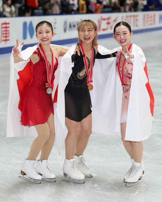 優勝し笑顔を見せる坂本花織（中央）。左は２位の千葉百音。右は３位の青木祐奈＝９日、東京・国立代々木競技場