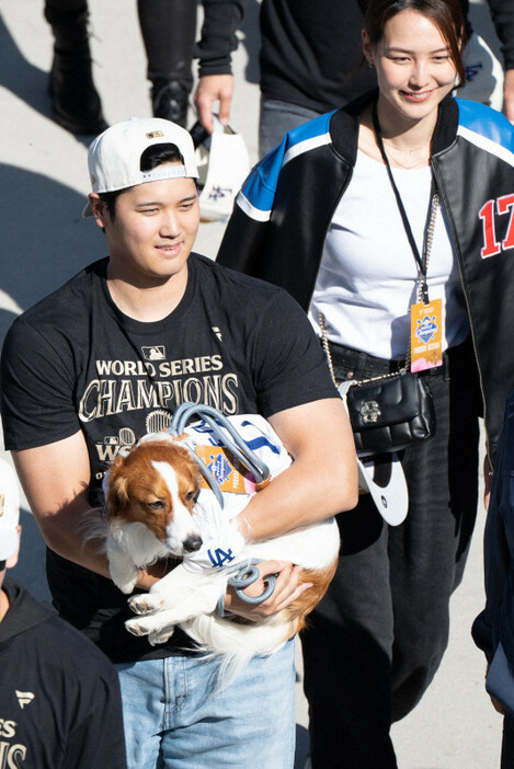 ドジャースタジアムで開催された優勝報告会で、愛犬のデコピンを抱く大谷と妻の真美子さん＝ロサンゼルスで2024年11月1日、Imagnロイター