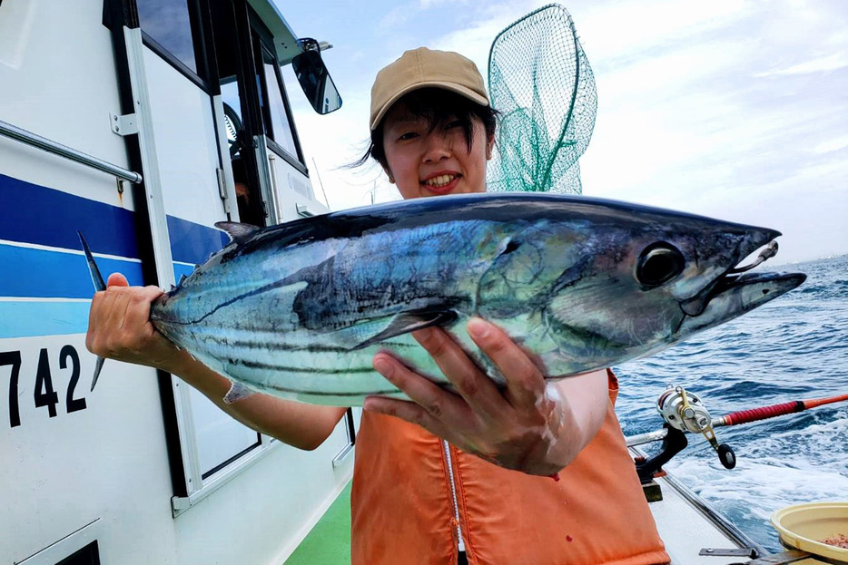 船釣りでカツオを釣り上げた女性