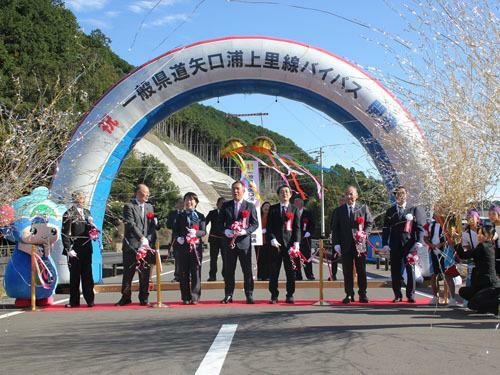 【県道矢口浦上里線のバイパス工事の完成を祝う出席者ら＝紀北町矢口浦で】