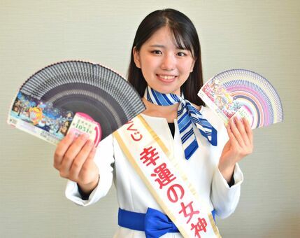 年末ジャンボ宝くじと年末ジャンボミニをＰＲする幸運の女神の岡田桃果さん＝２５日、沖縄タイムス社