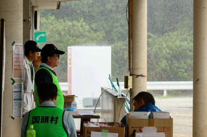 強い雨が弱まるのを待つ住民ら＝16日午後2時、国頭村比地（大城直也撮影）