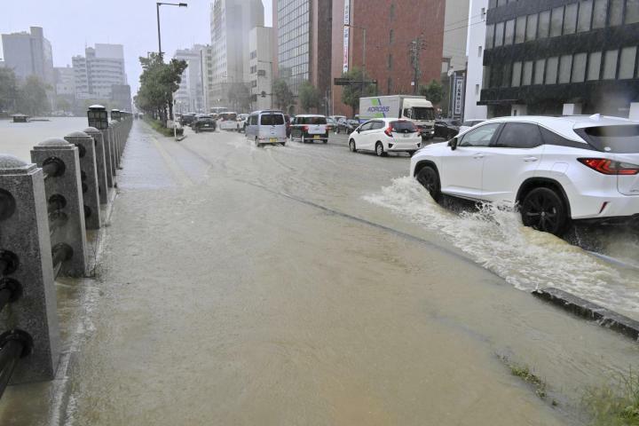 城山公園の堀から濁った水があふれ、冠水した道路＝2日午後0時10分ごろ、松山市本町1丁目