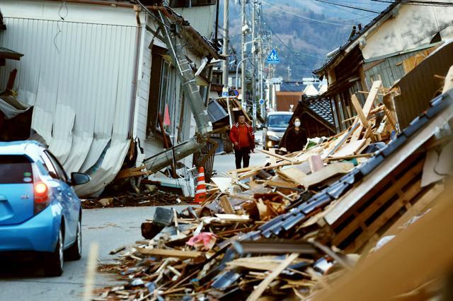 倒壊した住宅などで道幅の半分がふさがってしまっている道路=2024年1月20日、石川県輪島市鳳至町、長島一浩撮影