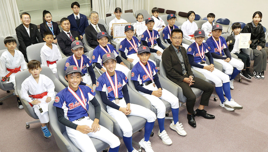 杉本さん（後列真ん中）ら国際大会や全国大会で優秀な成績を収め、竹上市長に報告した選手たち＝市役所で