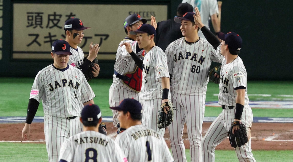 ＜日本・米国＞勝利し、ナインがタッチを交わす中、ウイニングボールを見つめる小園（左から2人目）（撮影・光山　貴大）