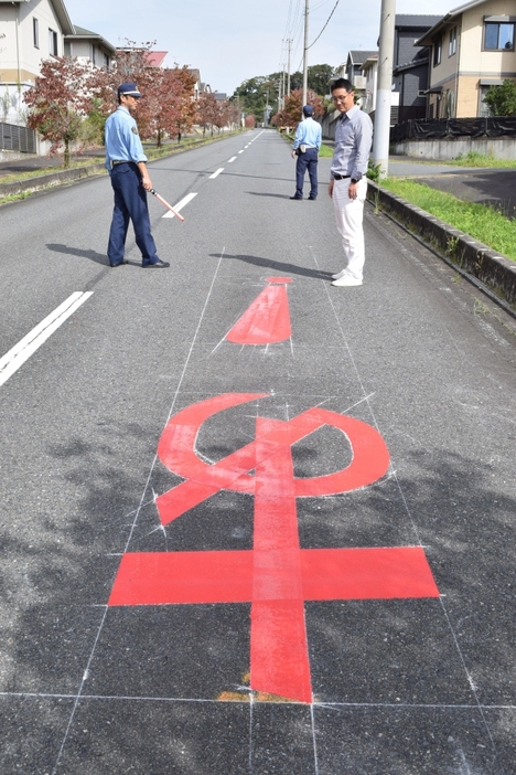 交通安全対策として路面にペイントされたひらがなの「あ」とびっくりマーク=10月31日、五條市なつみ台1の市道