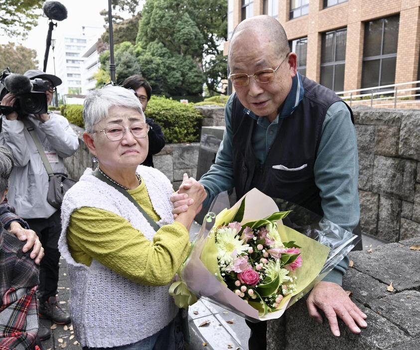 旧優生保護法下の強制不妊手術を巡る訴訟で和解が成立し、名古屋高裁前で喜びをかみしめる原告の尾上敬子さん（左）と夫の一孝さん＝15日午後、名古屋市