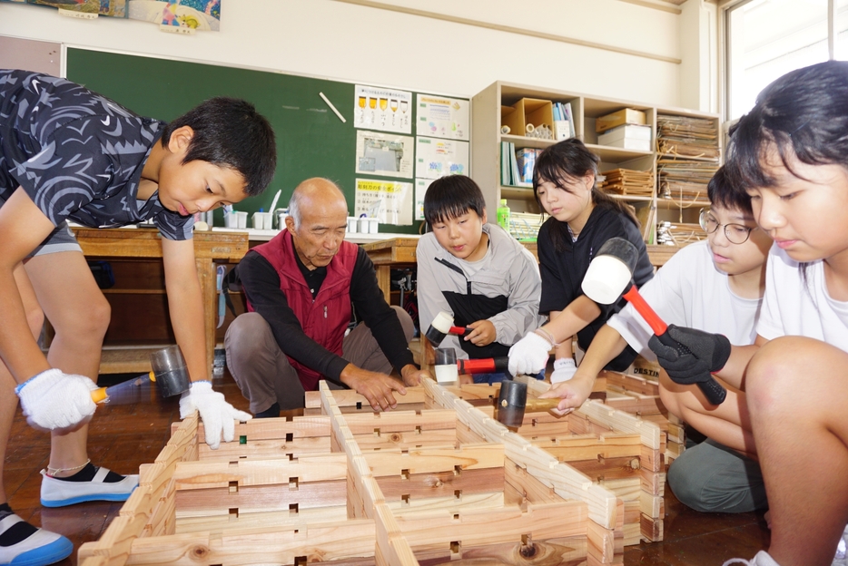 ハンマーを使って間伐材の組手什を組み立てる児童＝兵庫県丹波篠山市乗竹で