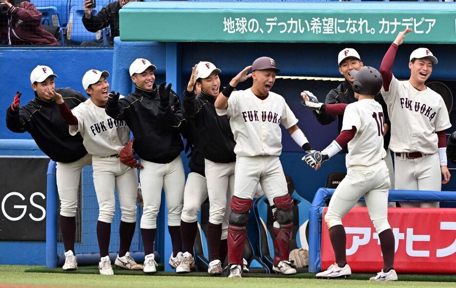 1回無死一、三塁、田中の先制適時打で生還した幸（10）を迎える福岡大ベンチ（撮影・冨永豊）