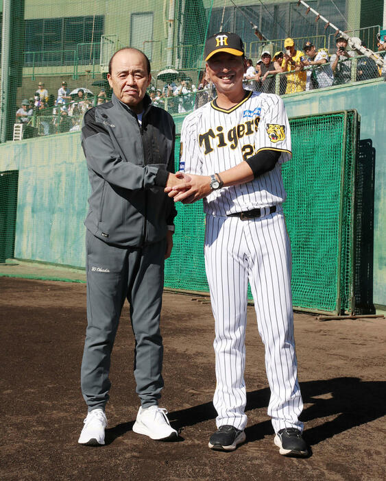 秋季キャンプを視察に訪れた岡田オーナー付顧問（左）と握手する藤川監督（撮影・加藤哉）