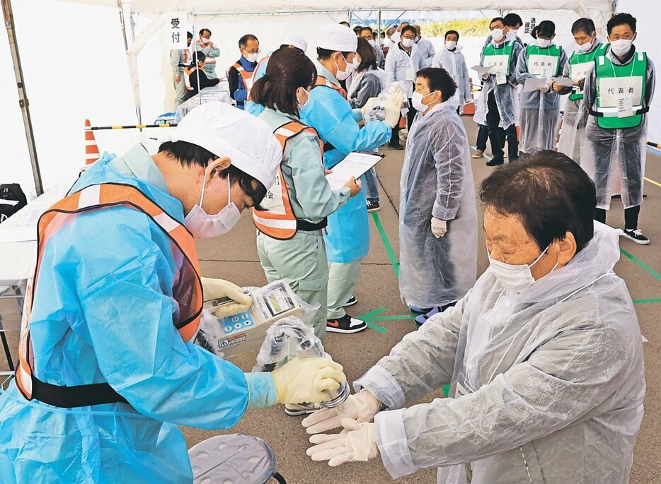 放射線量を測定する訓練に参加する住民ら＝氷見運動公園