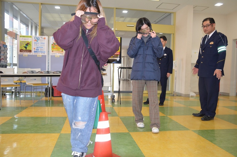 飲酒体験ゴーグルを装着して歩く学生（山口東京理科大で）