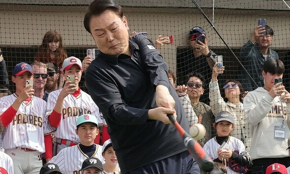 尹錫悦大統領が今年3月16日、ソウルの龍山子ども庭園野球場で開催されたサンディエゴ・パドレスの子ども野球教室で、少年野球の選手たちが見守る中、自ら打席に立っている=大統領室写真記者団