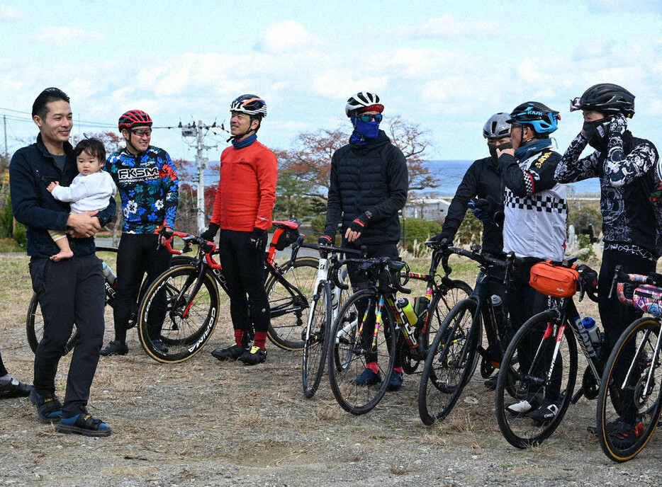 出発する福島県ロードバイク愛好会のメンバーを見送る野田翔一郎さん（左端）＝富岡町仏浜で２０２４年１１月２４日、錦織祐一撮影