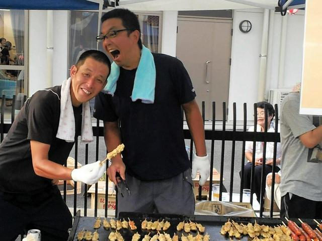 夏祭りで焼き鳥を手にする非々篤史さん（左）と森谷公洋さん=島根県川本町因原、森谷さん提供