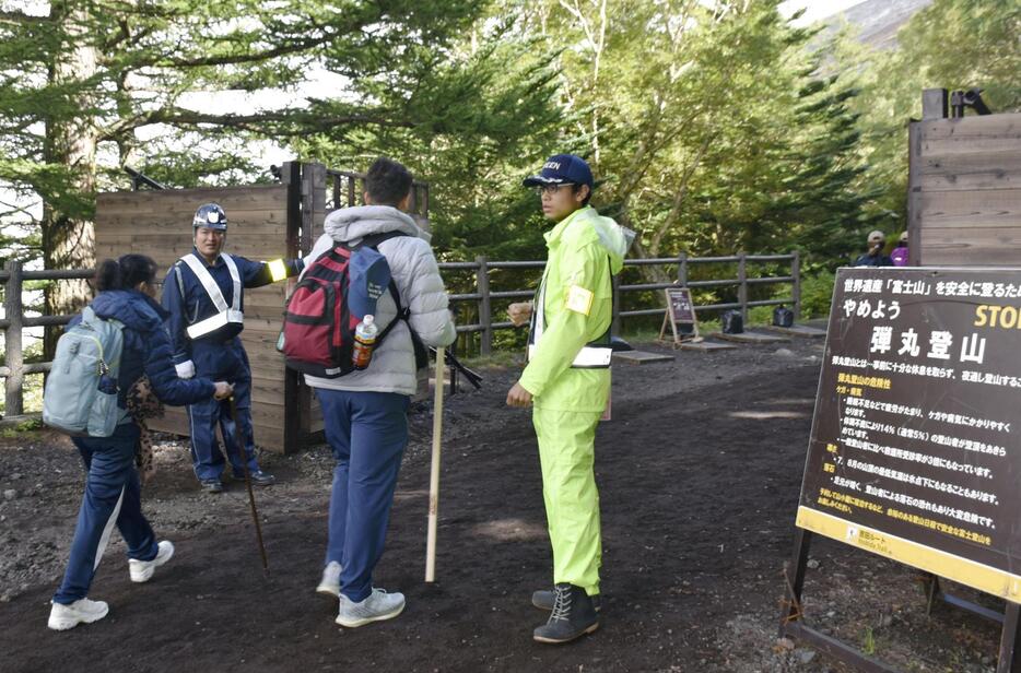 富士山5合目に設置されたゲートを通過する登山者＝9月、山梨県