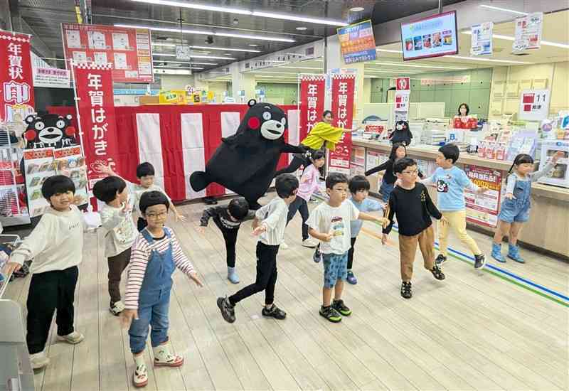 年賀はがき発売を前に、歌とダンスを披露する一新幼稚園の園児ら＝1日、熊本市中央区