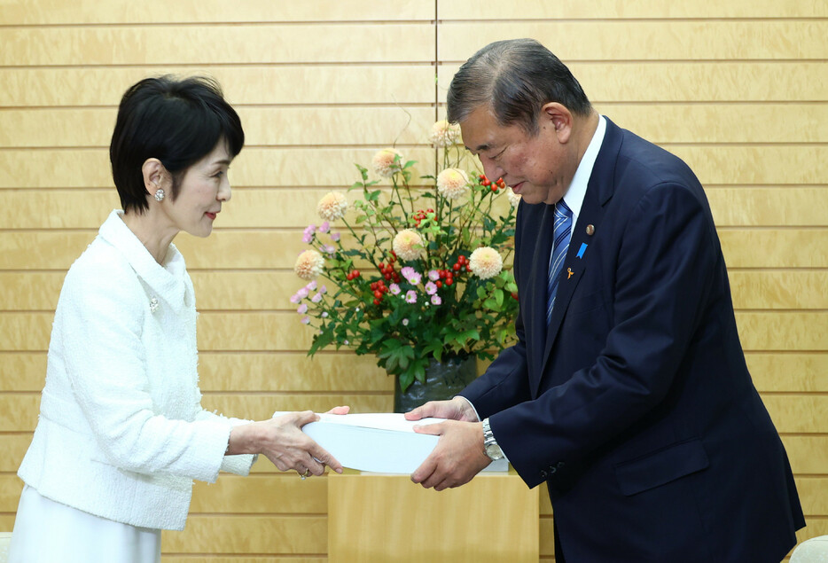 田中弥生会計検査院長（左）から２０２３年度決算検査報告書を受け取る石破茂首相。税金の無駄遣いなどを指摘した事業は３４５件、金額は計約６４８億６２００万円で、いずれも前年度を上回った＝６日午後、首相官邸