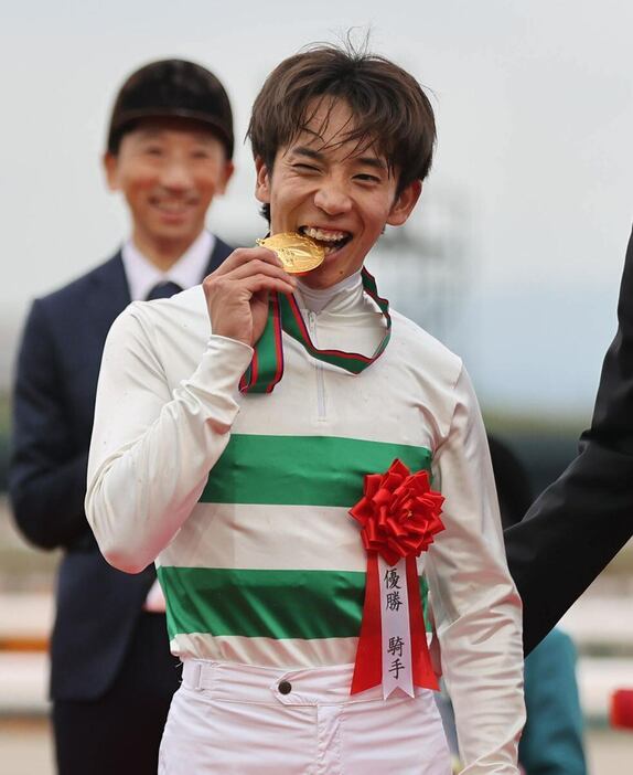 メダルをかじる団野大成騎手＝京都競馬場（撮影・安部光翁）