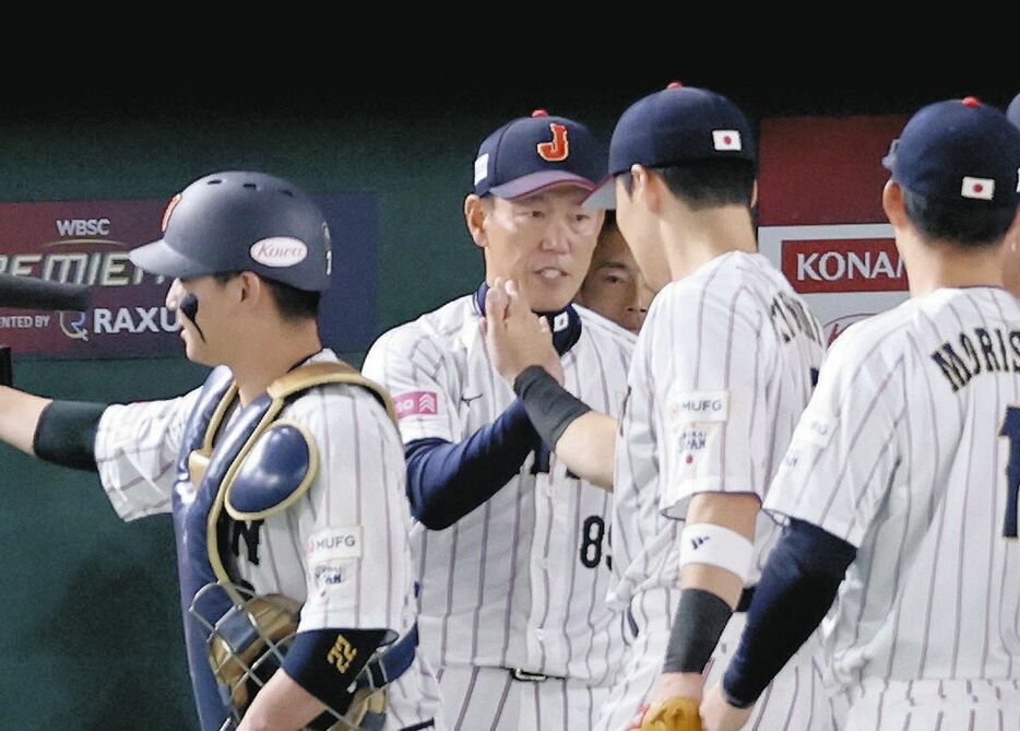 台湾を破り、日本ナインとタッチを交わす井端監督（中央）