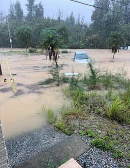 大雨の影響による冠水にはまって流されたレンタカー＝10日午前9時55分ごろ、沖縄県恩納村名嘉真(読者提供)