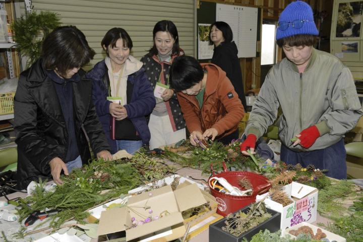 全て県産のスギやヒノキ、松ぼっくりなどを使ってクリスマスリースづくりを楽しむ参加者ら＝30日午前、東温市河之内