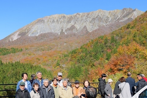 大山を背景に記念撮影する観光客＝鳥取県江府町大河原、鍵掛峠展望台