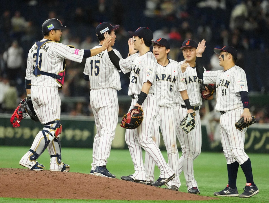 ＜日本・ベネズエラ＞勝利しハイタッチするナイン（撮影・島崎　忠彦）