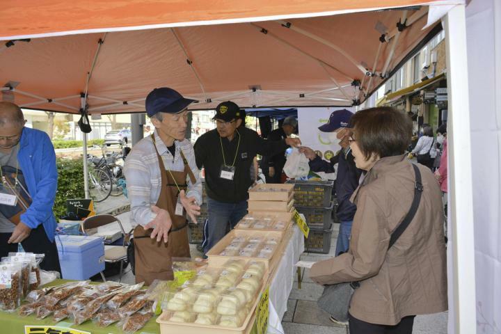 来場者に商品の特長を説明する出店者＝10日午前、松山市花園町