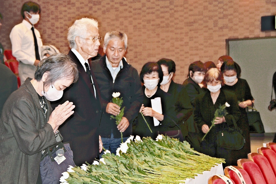 献花し祭壇に手を合わせる参列者ら