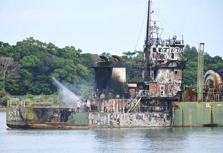 火災船の消火活動に当たる海保の隊員ら＝２６日午前９時半ごろ、今帰仁村・羽地内海