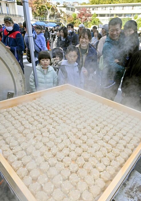 巨大角せいろで蒸されたシューマイに見入る人たち＝23日午前11時45分、鹿沼市今宮町