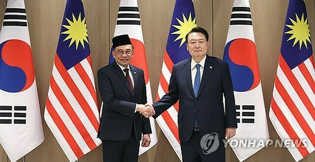 首脳会談前、握手を交わす韓国の尹大統領（右）とマレーシアのアンワル首相＝25日、ソウル（聯合ニュース）