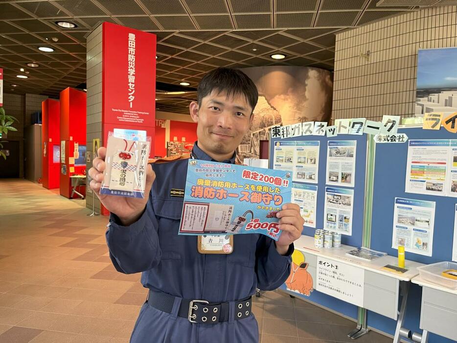 「消防ホース御守り」を手に呼びかける吉川さん