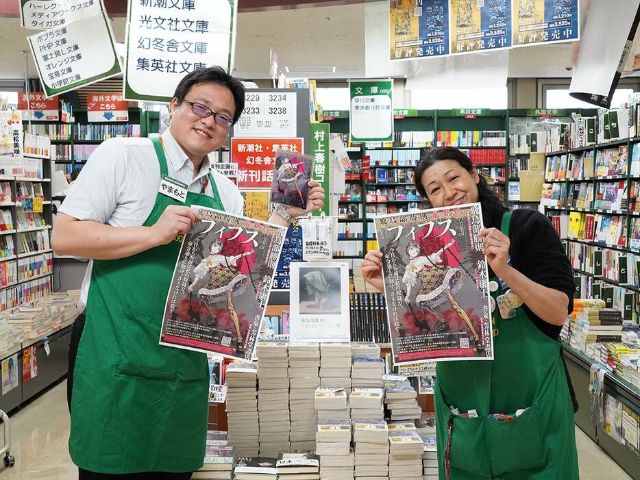 「フィフス」のポスター、アクリルプレートを持つ芳林堂書店高田馬場店の山本善之店長（左）とスタッフ