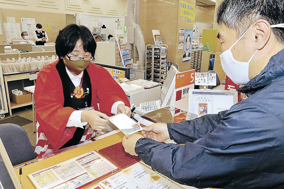 年賀はがきを販売する局員＝富山市の富山中央郵便局